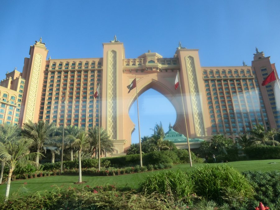 Hotelgebäude mit großem Bogen und Palmengarten